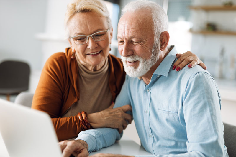 elderly couple discussing_dental options together on computer